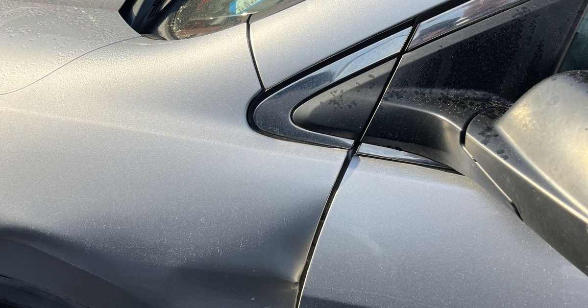 Dent in a car door panel ready for repair