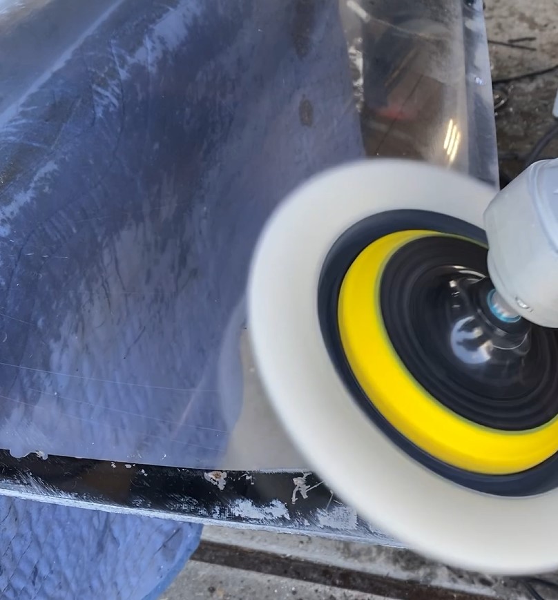 Buffing a plexiglass panel with a polishing tool at Autoseum