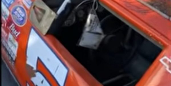 Orange Schneider-branded Chevrolet race car with weathered paint and sponsor decals before restoration
