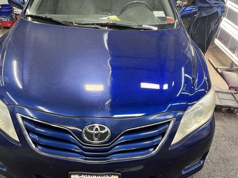 Sedan being sanded and polished in the bay